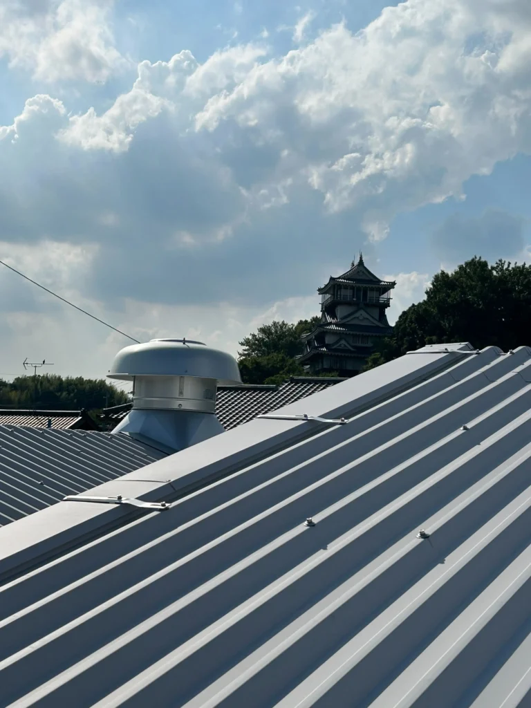 岩崎城を背景にした徳仲（株）の屋根と新設ダクト
